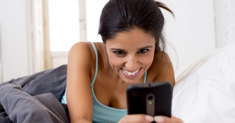 woman looking at her phone and smiling