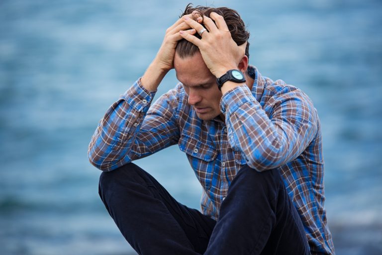 Man with hands on head - Money Stress Vs. Financial Anxiety