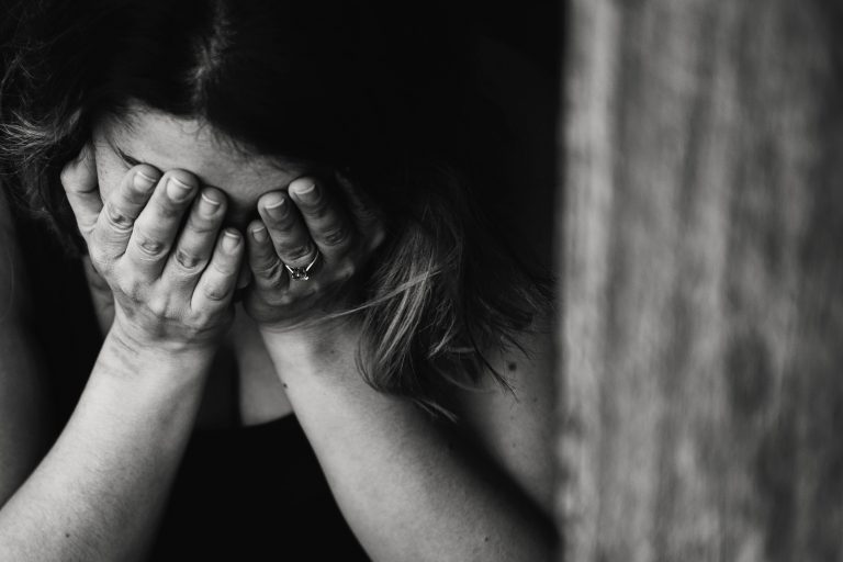 photo of sad woman with hands over her eyes