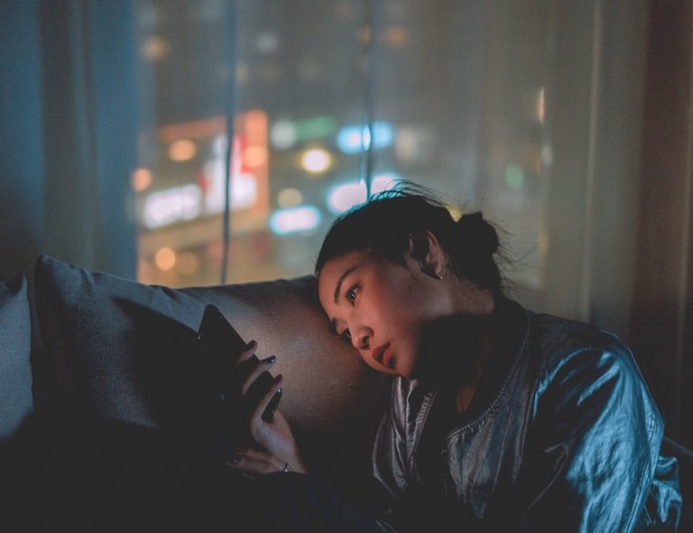 woman holding a phone in the dark