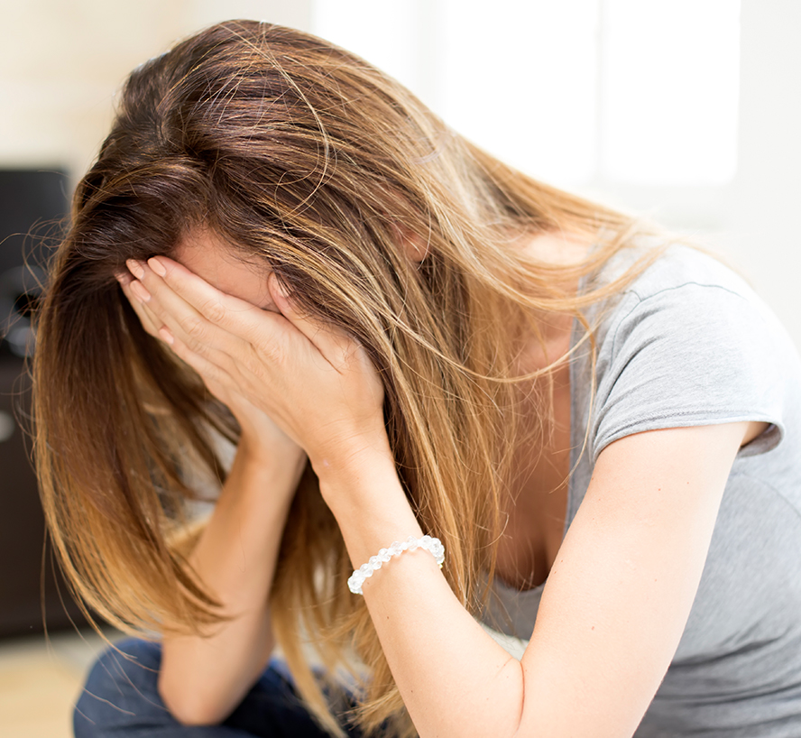 Image of a girl crying into her hands