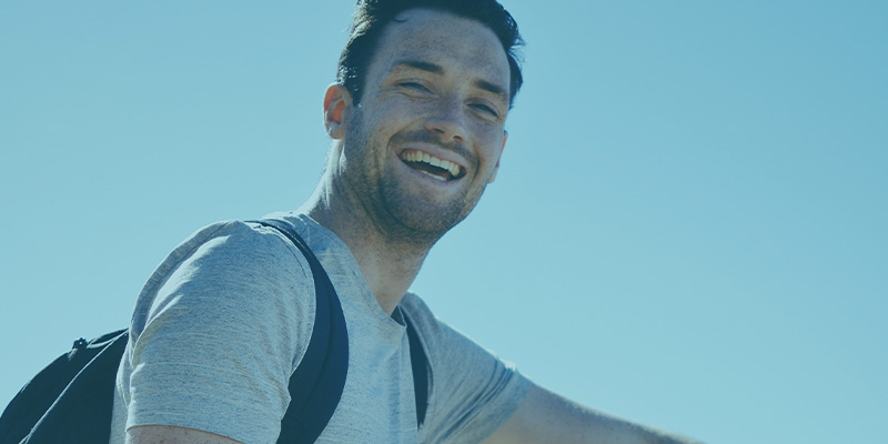 Man smiling while wearing a backpack