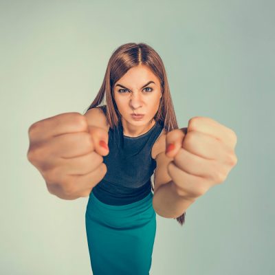 Closeup,Portrait,Angry,Young,Woman,Showing,Fists,About,To,Punch